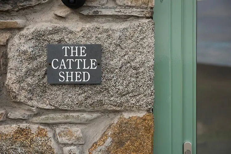 slate sign on side of cottage